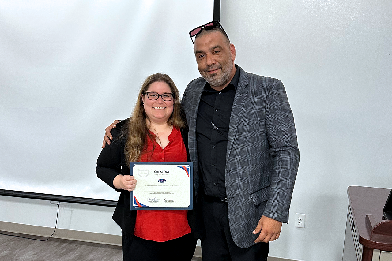Jasmine Valdez holding a certificate smiling, standing with Associate professor Gabriel T. Cesar