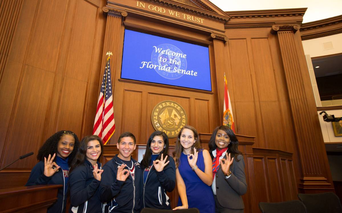 Students holding up Owl Fingers in the Florida Senate House