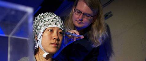 woman wearing brain scanner while being examined