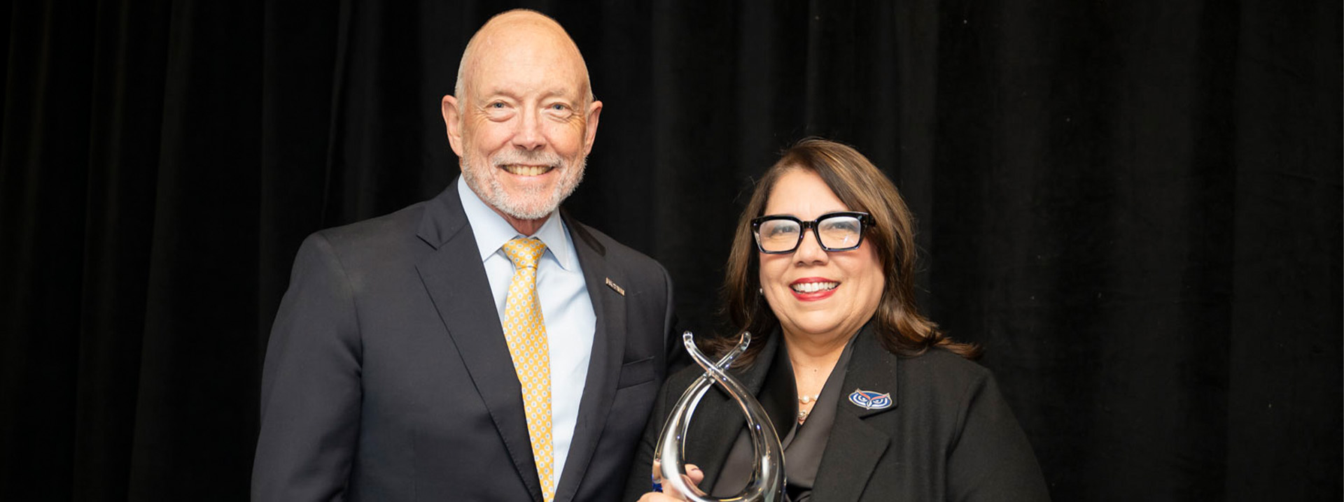 Ted Mitchell, president of ACE, presents FAU President Stacy Volnick with the 2024 American Council on Education