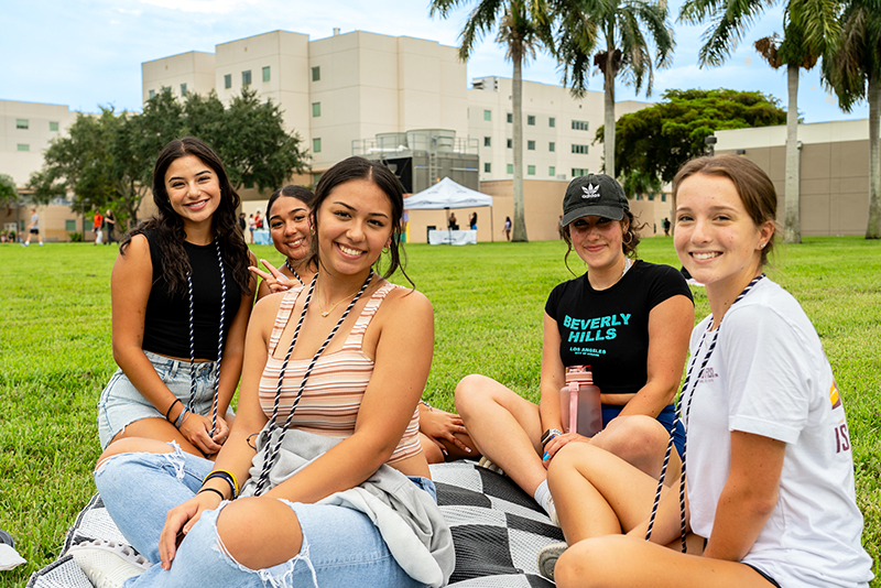 a group of student hanging out together on the Housing Lawn during Red and Blue Weeks