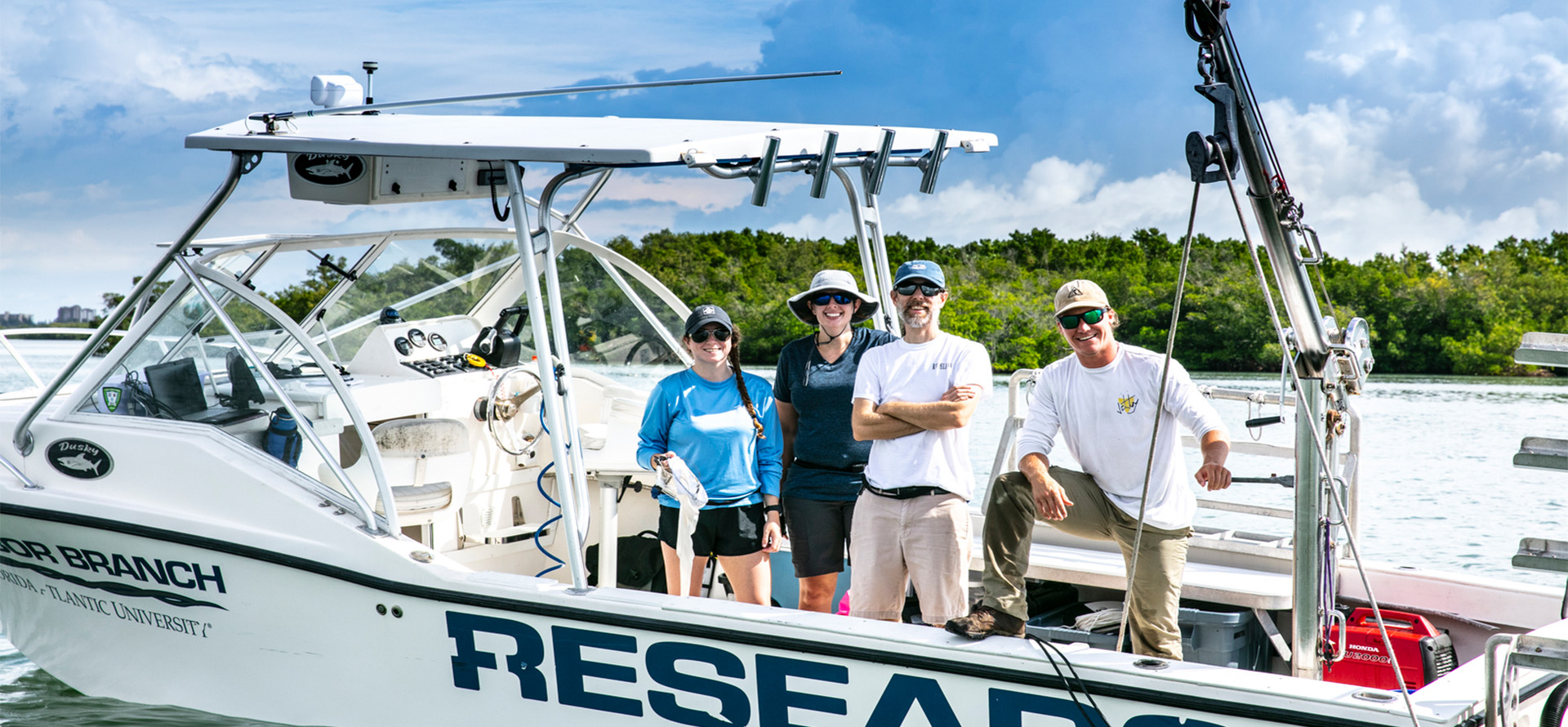 Four people standing in a reasearch boat