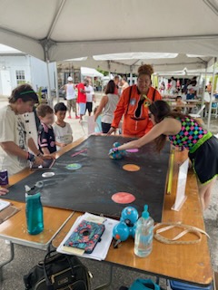 Dr. Jillian Powers (right) and Erika Snowbridge (center) dressed in space-themed costumes to teach children how to code the Dash robot to visit different planets in the solar system. 