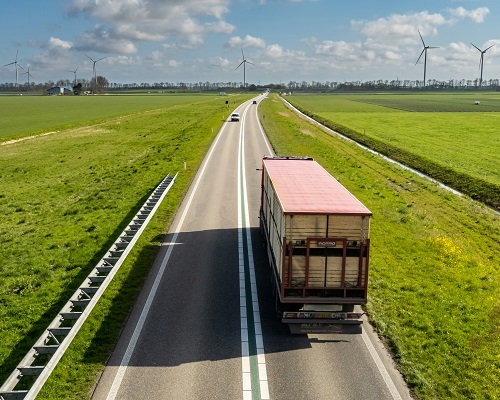 Coordination of Connected and Automated Trucks for Platooning Considering Turning Along an Arterial Corridor 