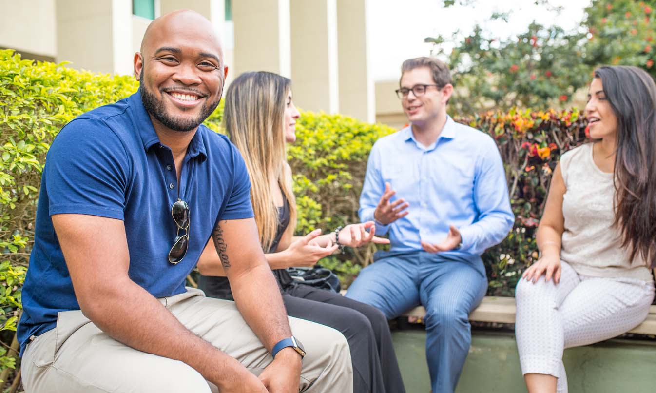 Four FAU Students smiling on campus