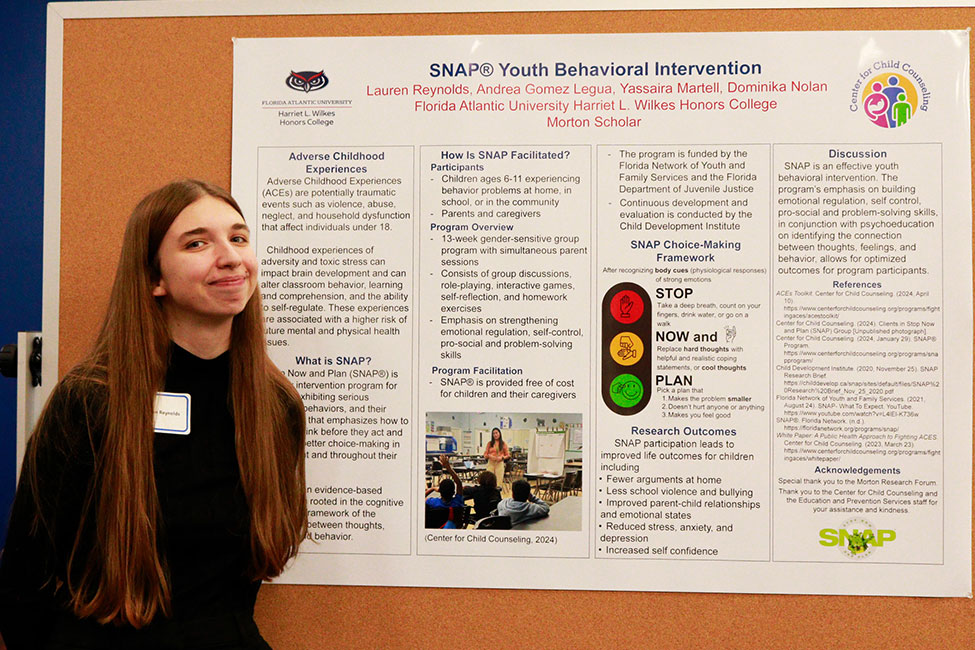 Lauren Reynolds standing in front of her research poster.