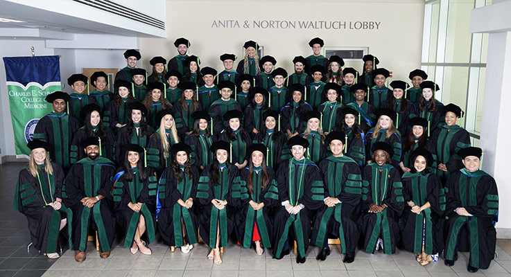 FAU Schmidt College of Medicine graduates taking group picture at 2024 commencement ceremony