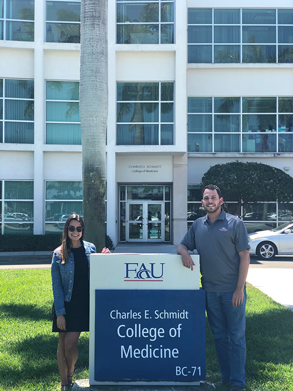 Dr. Kenan Ashouri and Dr. Annie Lopez-Ashouri in front of Schmidt College of Medicine building at Boca Raton