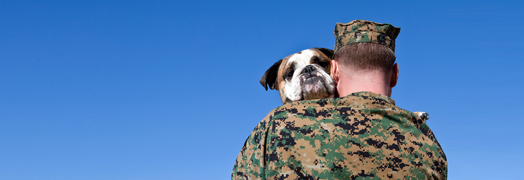 veteran in uniform holding a dog