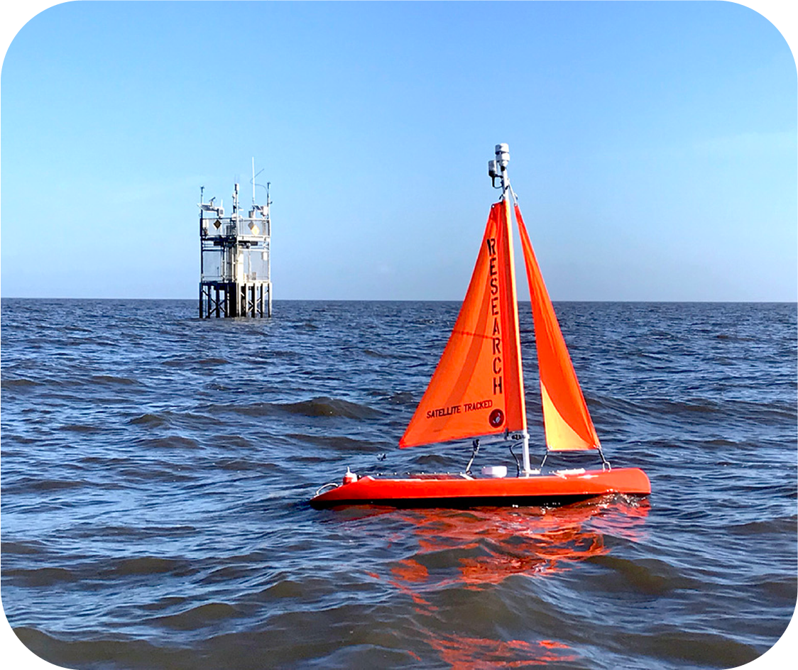 man holding on to autonomous sailboat