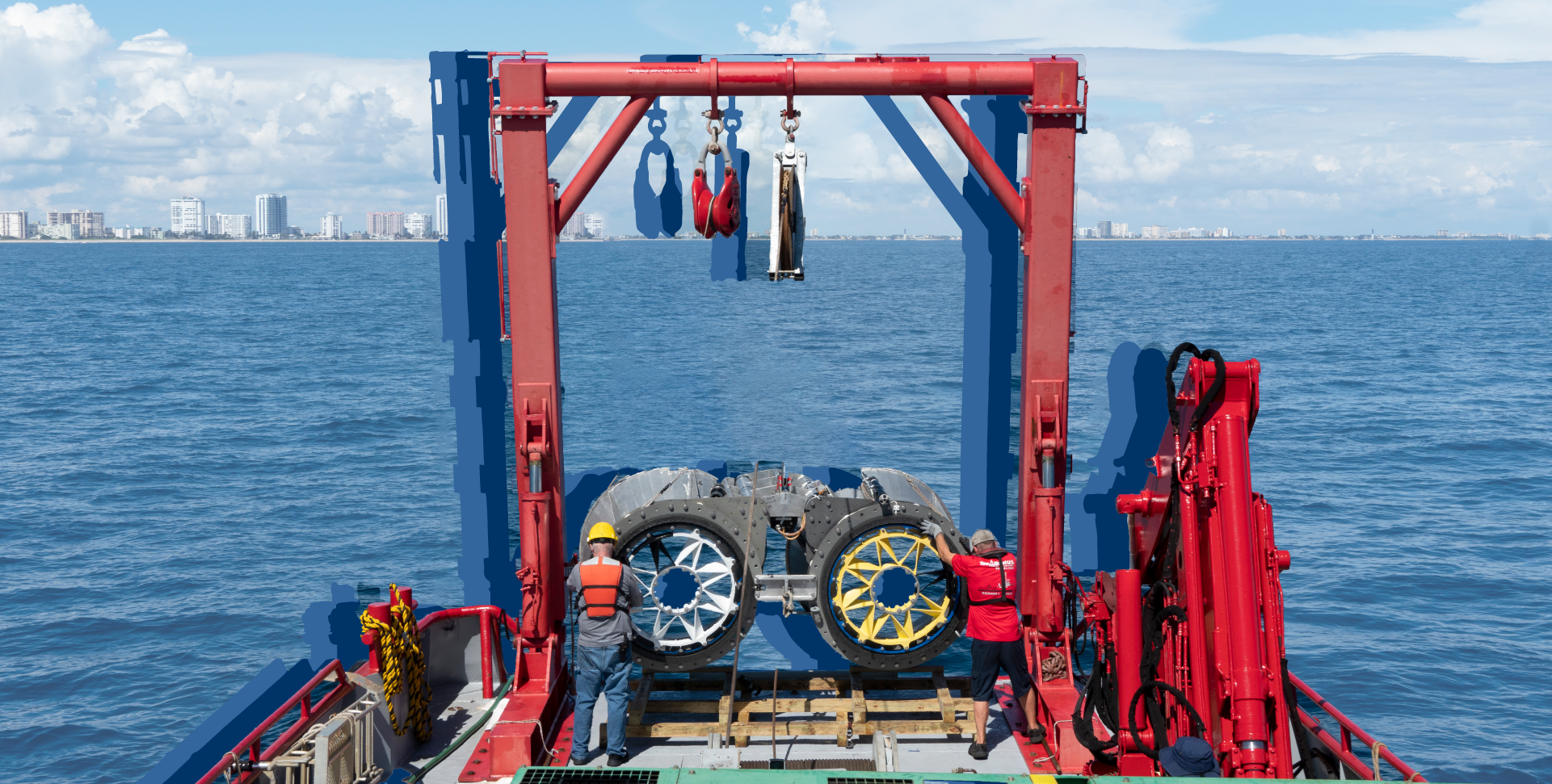 image of turbines with ocean and city in background