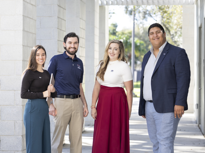 Four Graduate college students smilling