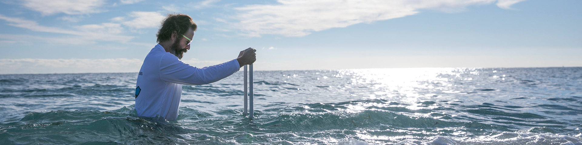 Video still image of a person conducting an experiment in the ocean.